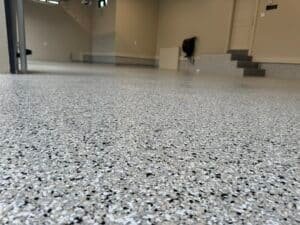 Close-up of UV-stable polyaspartic flake coating reflecting light in a garage