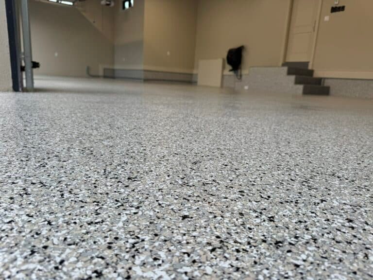 Close-up of UV-stable polyaspartic flake coating reflecting light in a garage