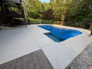 Slip-resistant polyaspartic pool deck with decorative flake finish under sunlight