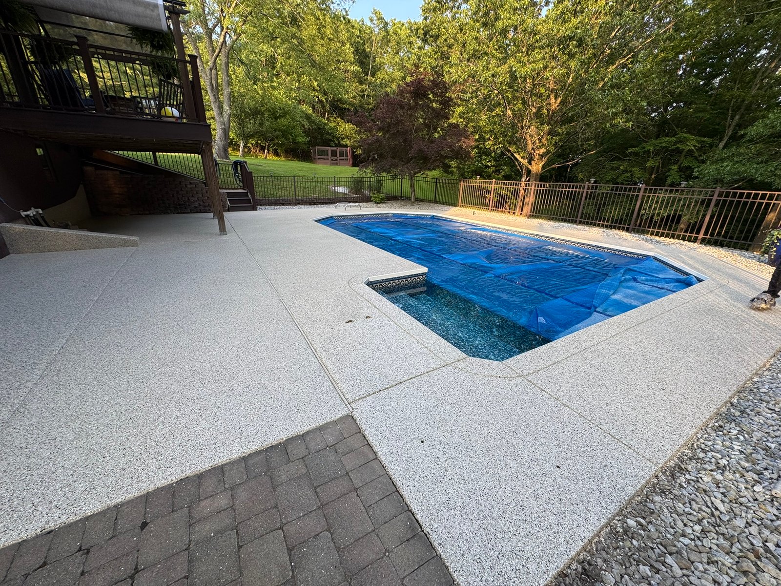 Slip-resistant polyaspartic pool deck with decorative flake finish under sunlight