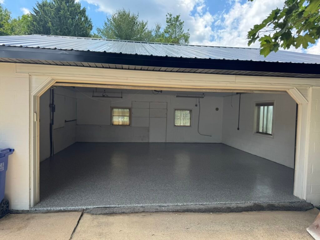 Charcoal and white flake garage floor coating, wide view toward driveway