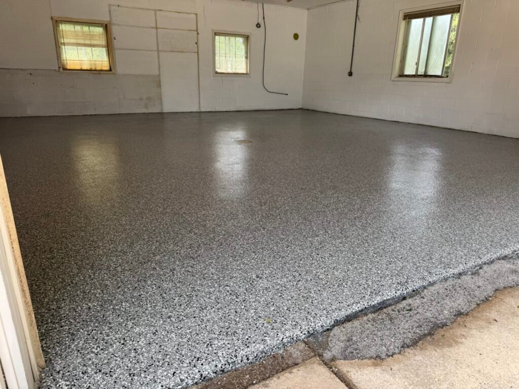 Close-up of charcoal, white and tan flake broadcast garage floor coating