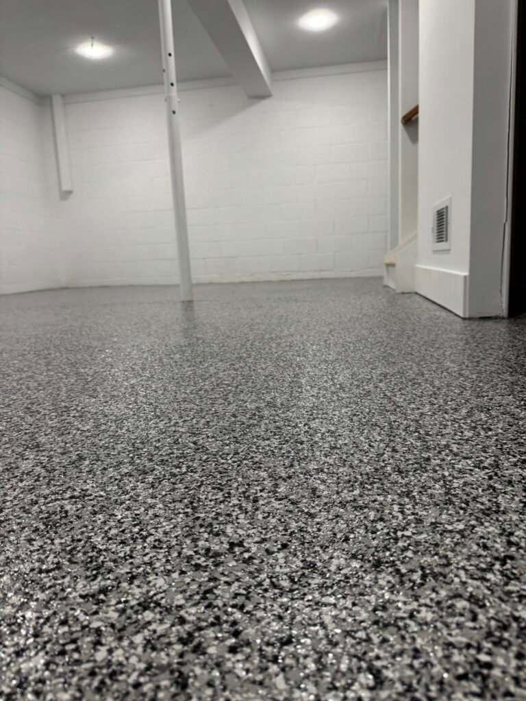 Dark gray, black and white flake basement floor coating, angled view