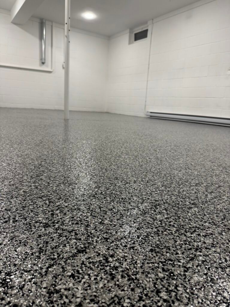 Dark gray, black and white flake basement floor coating, wide view of finished basement