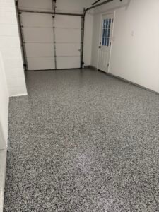 Black, gray and white flake polyaspartic garage floor coating after installation