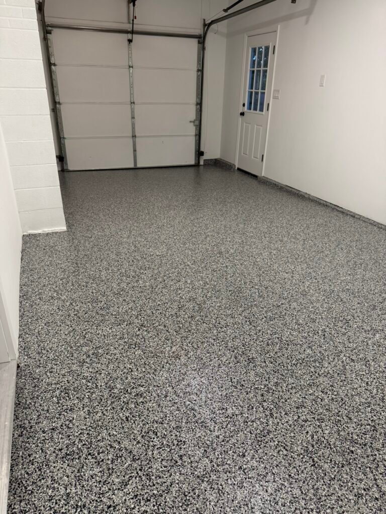 Black, gray and white flake polyaspartic garage floor coating after installation