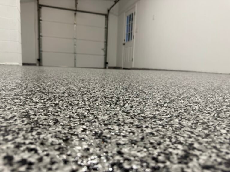 Black, gray and white flake garage floor coating near glass door