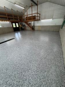 Wide view of finished gray, black and white flake pole-barn floor coating with mezzanine