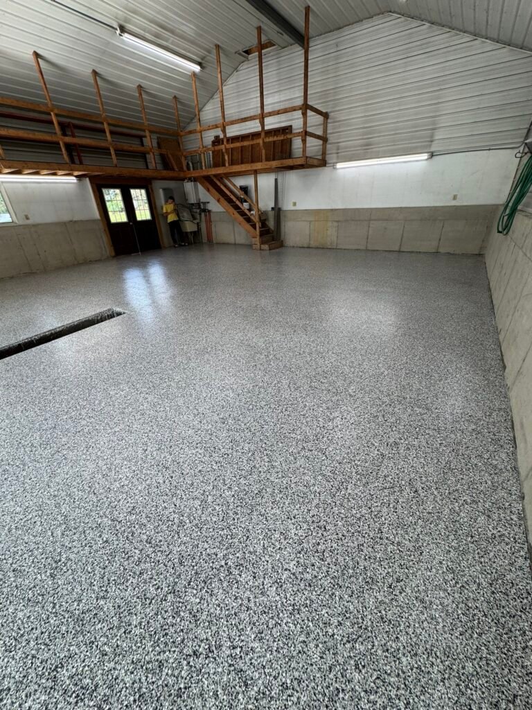 Wide view of finished gray, black and white flake pole-barn floor coating with mezzanine