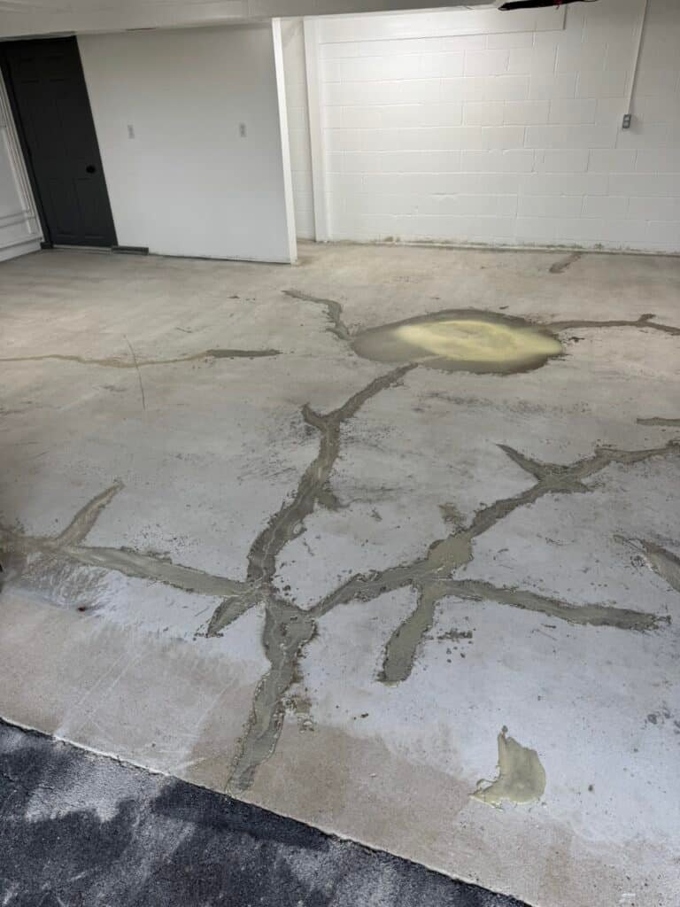 Crack repair filler applied to concrete garage floor before coating