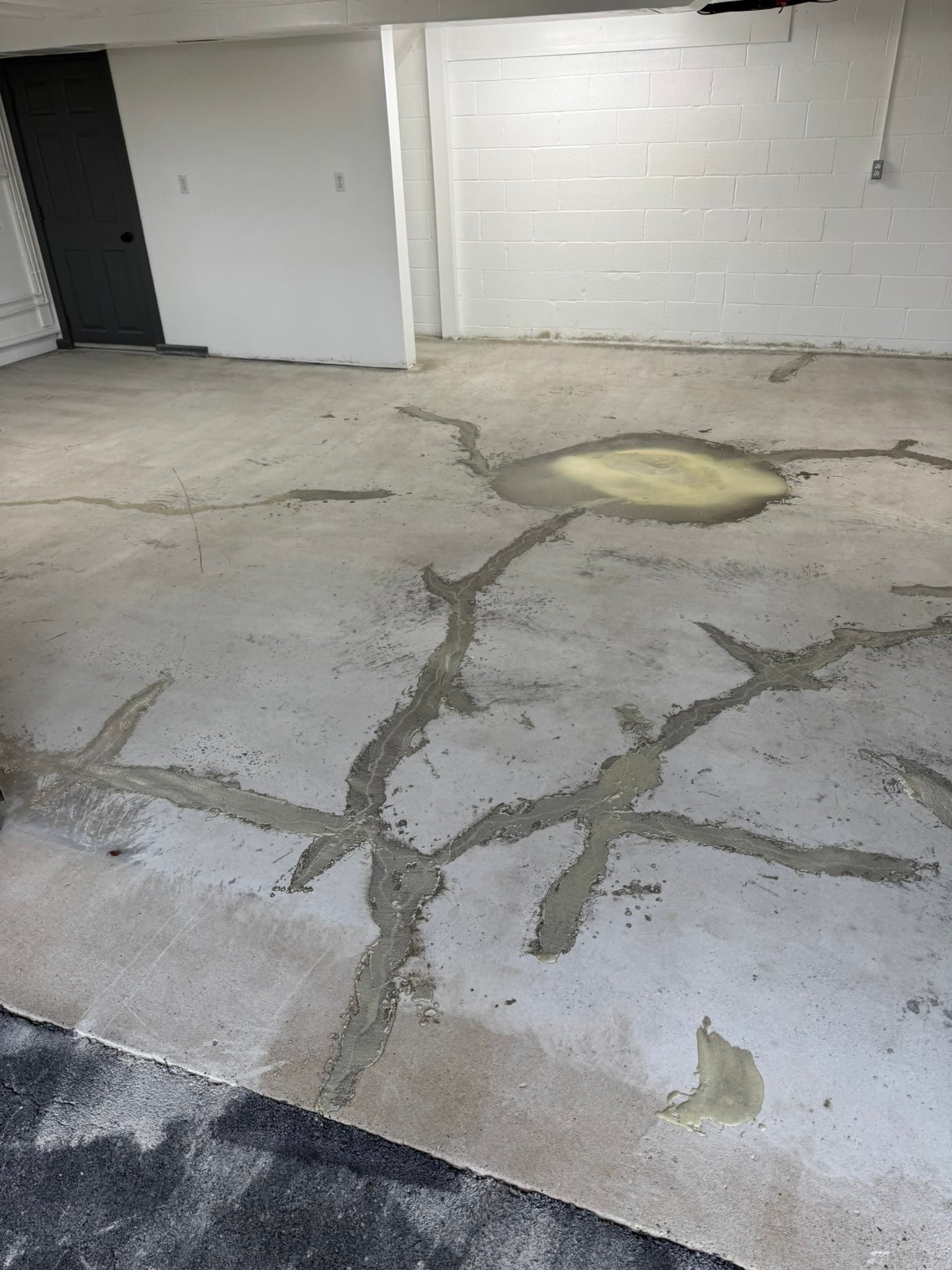 Crack repair filler applied to concrete garage floor before coating