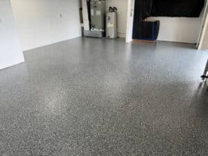 Dark gray, black and white flake garage floor coating near water heater and furnace