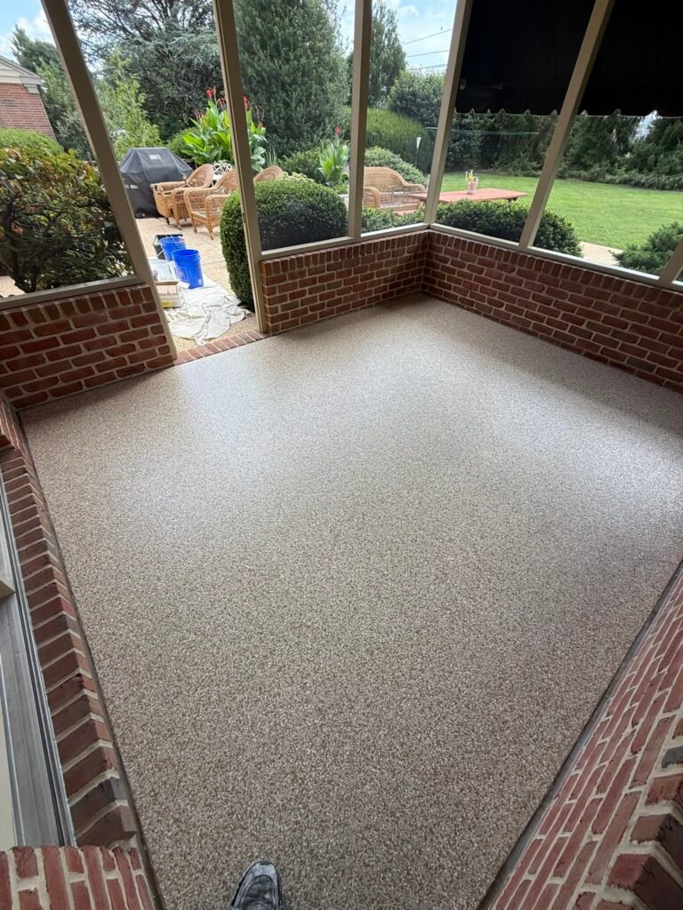 Tan, beige, black and white flake screened porch floor coating near wicker furniture
