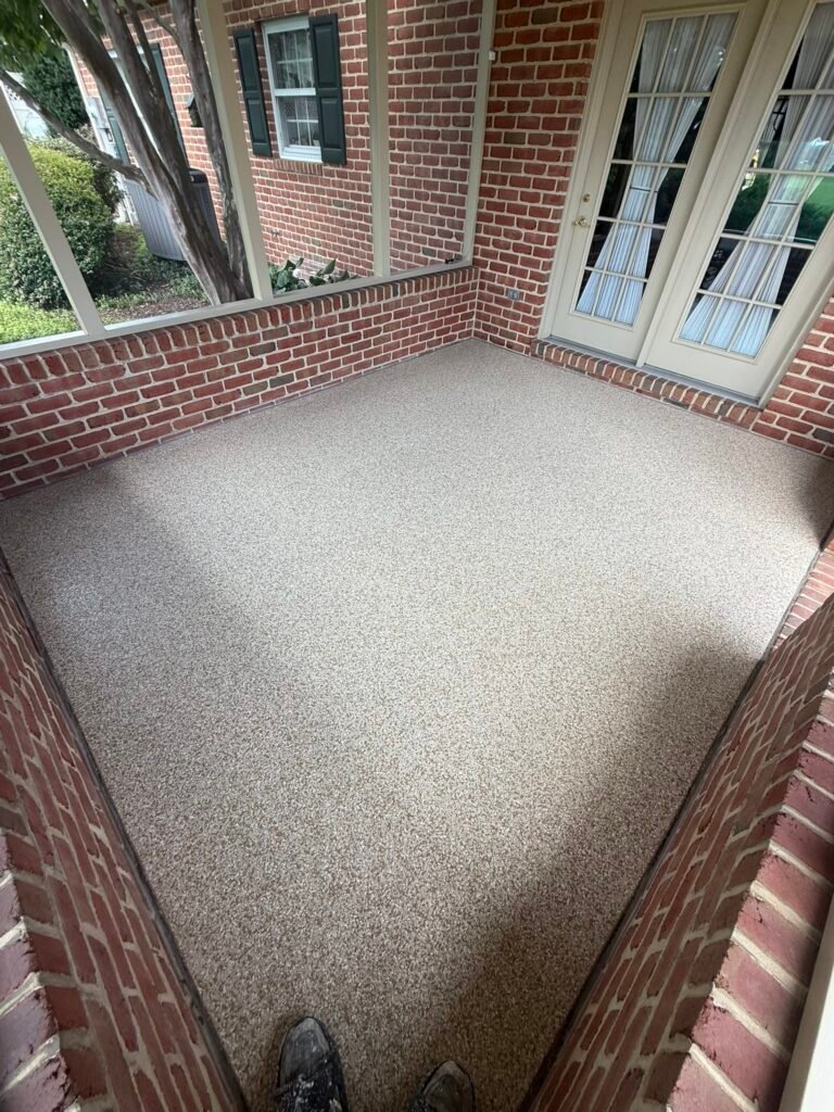 Tan, beige, black and white flake porch floor coating near brick exterior and French doors